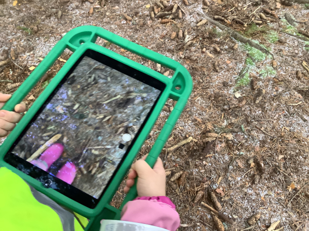 Lapsi kuvaamassa padilla maata.