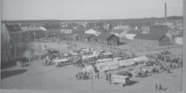 Vanha kuva Forssan torista, jossa on kojuja, ihmisiä sekä ajoneuvoja.